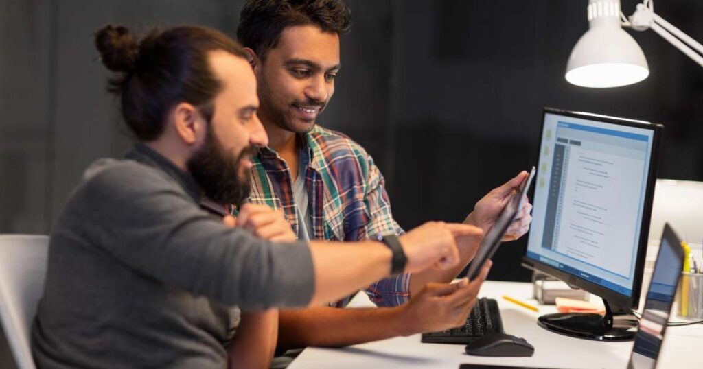 Coworkers collaborating on tablet and laptop
