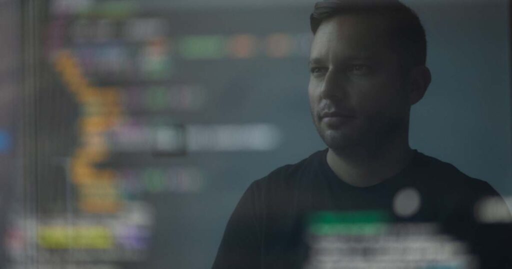 developer looking at code behind a screen overlay