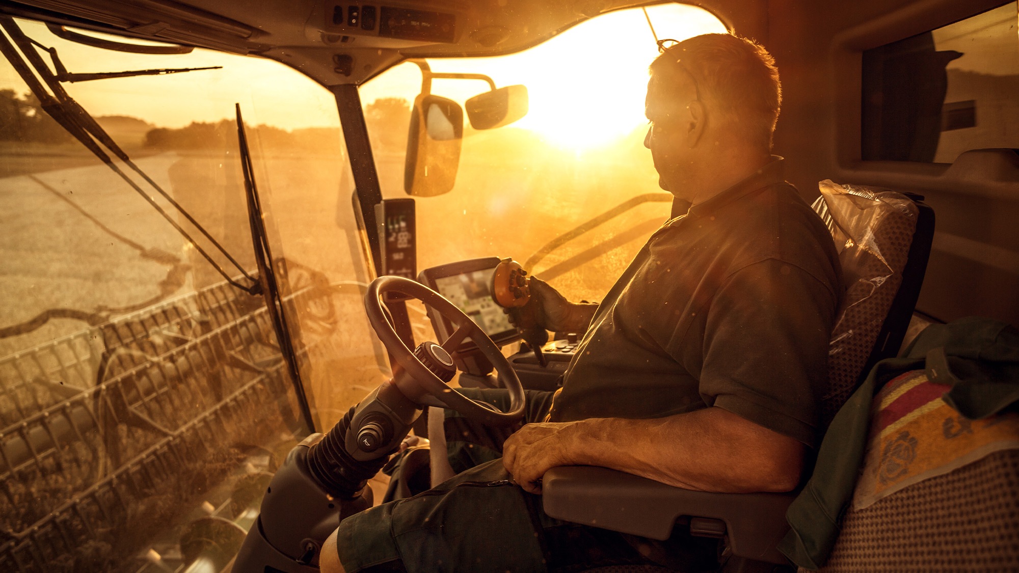 farmer driving a tractor with a smart display in the field