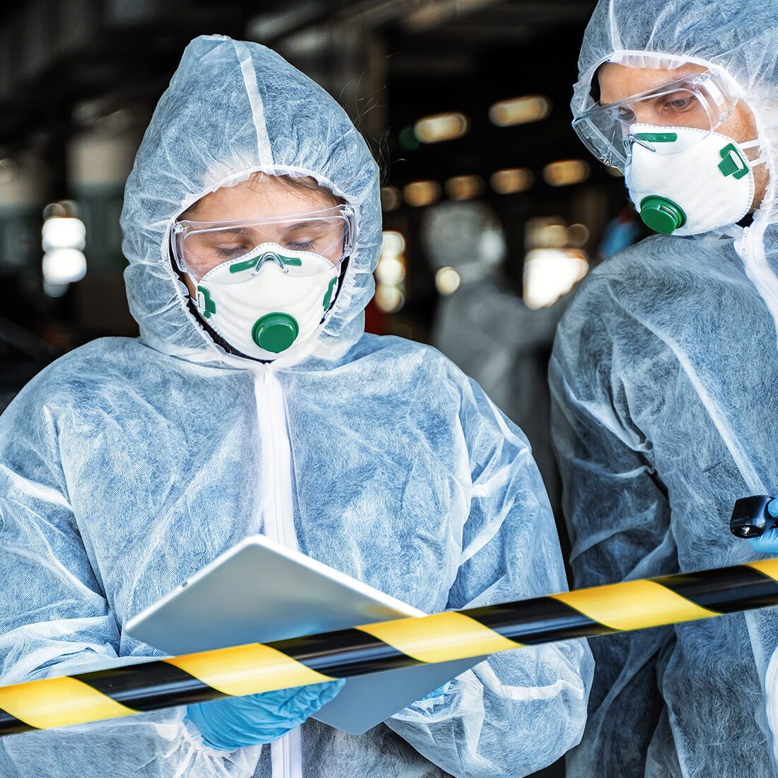 first responders in safety gear on tablet in the field